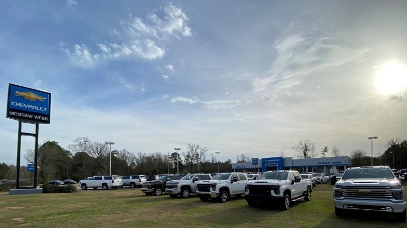 The front view of the McGraw-Webb Chevrolet Inc. building in CAMDEN AL with cars parked in the parking lot and grass